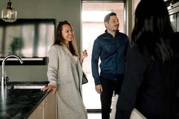 Couple talking with real estate agent at new home