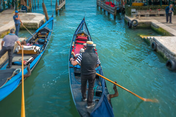 Fototapeta na wymiar Gondoliere riding his Gondola on a canal in Venice, Italy 