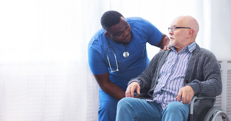 Fototapeta premium Professional doctor helps an elderly man with chronic diseases. Therapist and patient in home interior. Health care and medicine concept.