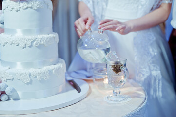 Brewing tea to the cake at the wedding. Tea ceremony during the wedding evening.