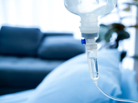 Close Up Of Set Vitamin Iv Fluid Intravenous Drip Saline Drop Near The Patient Bed In Hospital Room With Copy Space. Healthcare And Medical Concept.