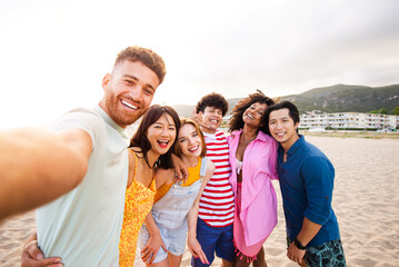 Group of young best friends bonding outdoors - Multiracial people bonding and having fun at the beach during summer vacation