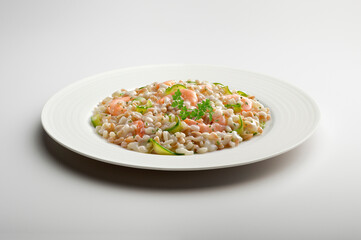 Barley spelled rice risotto with shrimps and courgettes and parsley in white plate