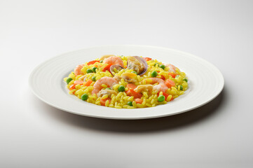 Flat plate with portion of fish paella with saffron vegetables