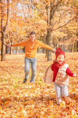 Naklejka na ściany i meble Happy father and daughter enjoying autumn. Happy father and daughter having fun in autumn park 