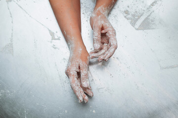 Fototapeta premium baker's hands in flour on the metallic table