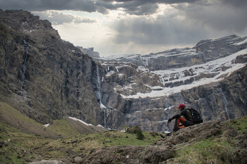 Fototapeta premium Waterfall cascade on mountain rocks. Mountain landscape with cloudy sky. Beautiful nature. Famous Gavarnie Falls in French Pyrenees, the highest waterfall in mainland France. The big waterfall. 