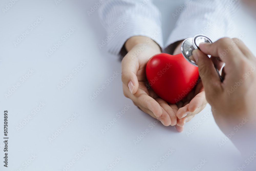 Wall mural a doctor uses a stethoscope with a fake heart in the patient's hand, treating the disease from a med