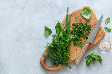 Fresh and chopped spicy herbs on cutting board