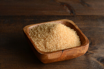 raw crystal sugar in a bowl on an old wood table