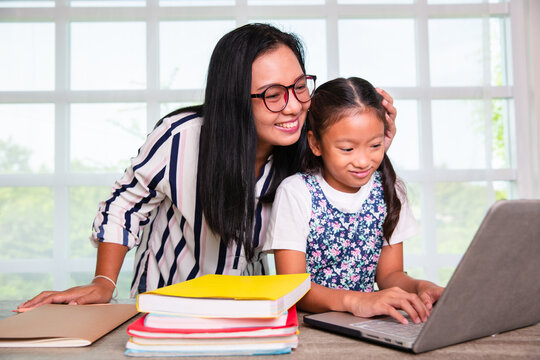 Primary school girl studying computer with teacher