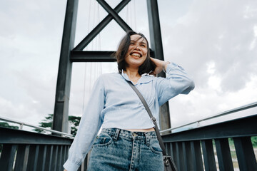 Happy beautiful women walking during a cross the bridge traveling on weekend and holiday trip, Resting time to journey lifestyle and freedom enjoy with a view, solo Asian women tourism relaxation.