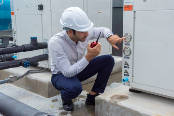 Engineer under checking the industry chilled water fan coil unit air conditioner is water cooling tower air chiller HVAC system of large industrial building to control air system 