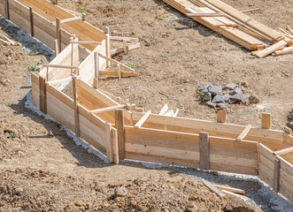 Wooden formwork for pouring concrete foundation of the house. Foundation construction.