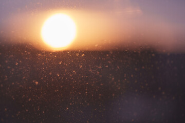 Closeup photo of dirty window with beautiful sunset on background