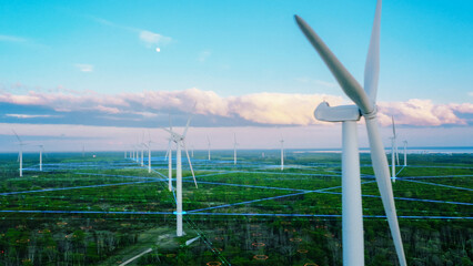 Scenic Aerial Drone Footage of Environmental Wind Turbines in a Forest Near the Sea. Green...