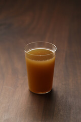 Apple celery juice in thin glass on wood table