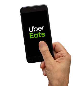 Los Angeles, California, USA - January 03, 2022 - Uber eats delivery application on smartphone black screen holding by hand.. Including clipping path.