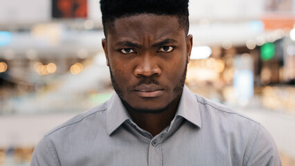 Male portrait serious pensive african american man looking at camera with confident look standing...