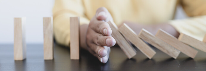 Businesswoman stops hands falling over domino to stop risk continuously, Continuous damage...