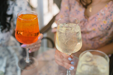 Summer fresh cocktails in glasses. Girls relaxing with drinks outdoors.