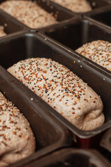 shaped bread raw dough in the molds before baking on the table in bakery