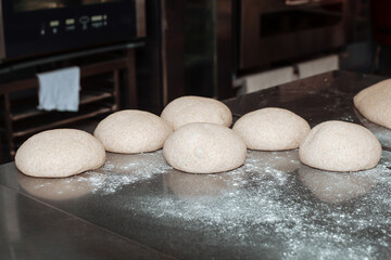 shaped bread raw dough before baking on the table in bakery