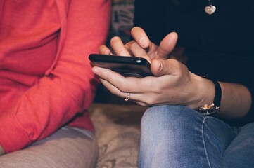 Two friends communicate, holding smartphone in hands