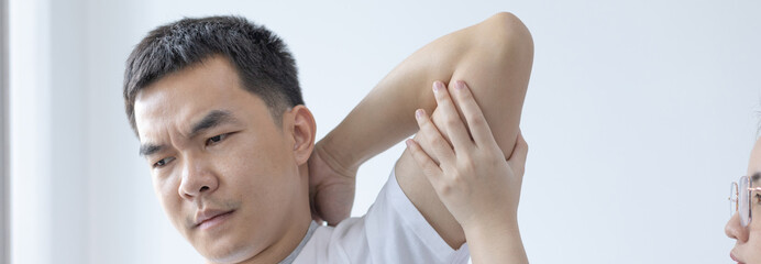 Fototapeta premium Physical therapy, Female physiotherapist treats arms and shoulders pain for a male patient attending in clinic, Bone arrangement, Non-surgical medical treatment, Modern medical techniques.