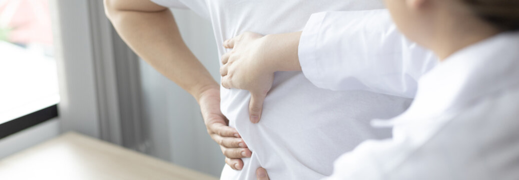 Physical therapy, Female physiotherapist treats back pain for a male patient attending a rehabilitation center, Bone arrangement, Non-surgical medical treatment, Modern medical techniques.