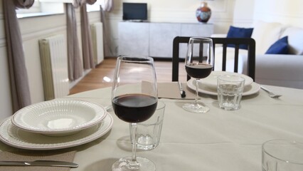 Table set with wine glasses, plates and crockery
