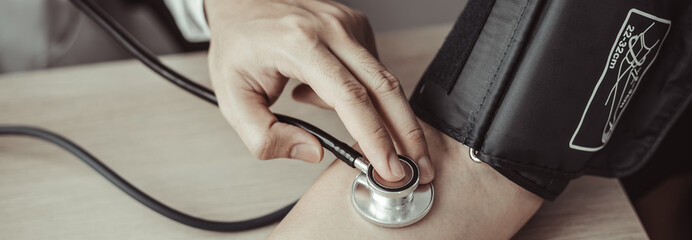 Man doctors use blood pressure monitors and stethoscope to measure pulse Diagnose the patient's disease in a modern hospital medical laboratory, Medical treatment and health check.