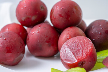 red plums on a white table