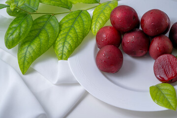 red plums on a white table