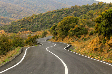 a paved road through green hills
