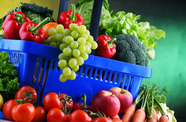 Fresh organic fruits and vegetables in plastic shopping basket