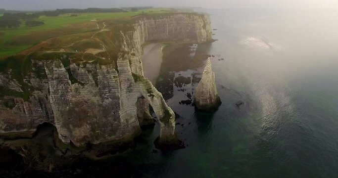 Aerial view of cliffs of Etretat at sunset. Etretat Normandy Shore Sea. France, Normandy, Aerial view of Etretat Aval cliff, rocks and natural arch landmark.
