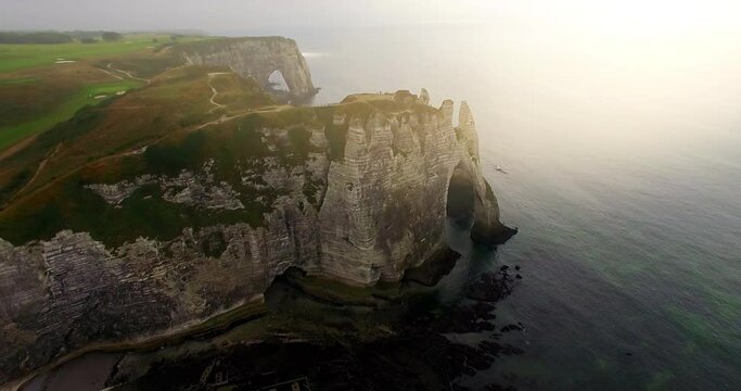 Aerial view of cliffs of Etretat at sunset. Etretat Normandy Shore Sea. France, Normandy, Aerial view of Etretat Aval cliff, rocks and natural arch landmark.