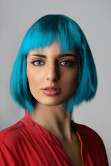 Beauty, fashion, makeup concept. Close-up studio portrait of beautiful and sexy woman in blue wig...