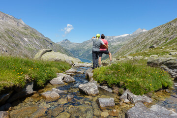 Zwei Wanderer blicken über die Alpen