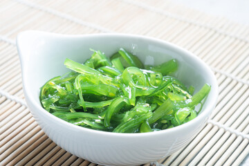 Japanese Wakame Seaweed Salad with Chopsticks, close up. Healthy vegetarian seafood