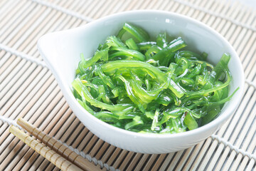 Japanese Wakame Seaweed Salad with Chopsticks, close up. Healthy vegetarian seafood