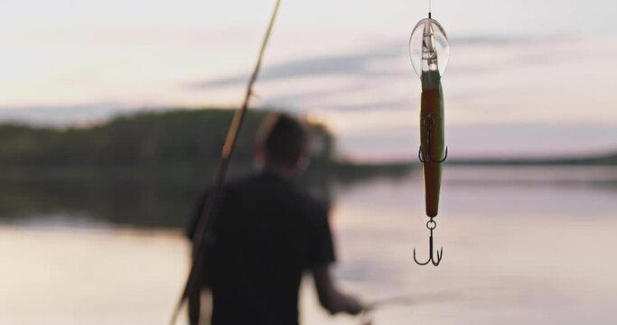 Close-up of a fishing hook on the background of the water surface.
