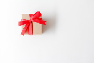 Brown paper gift box with red ribbon on white background. copy space, top view