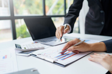 Business people meeting for marketing investment analysis ideas pointing to the graph at the office.