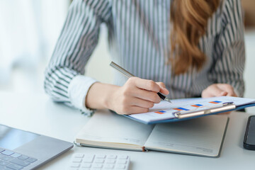 Close-up of businesswoman hands to check company finances and earnings and budget. Business woman calculating monthly expenses, managing budget,  papers, loan documents, invoices.