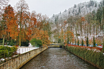 Karlovy Vary Czech Republic winter view with colored trees, snow covered hill and river in the...
