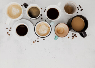 Top view on flat lay with many different full and empty coffee cups composition on gray white...