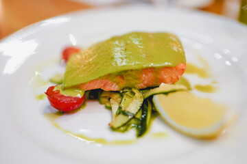 Baked fish with sauce in a white plate, restaurant serving