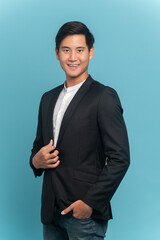 Young asian man in suit and jeans for smart casual business concept isolated on blue background